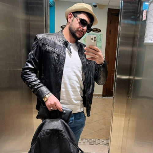 Maher taking a mirror photo in an elevator