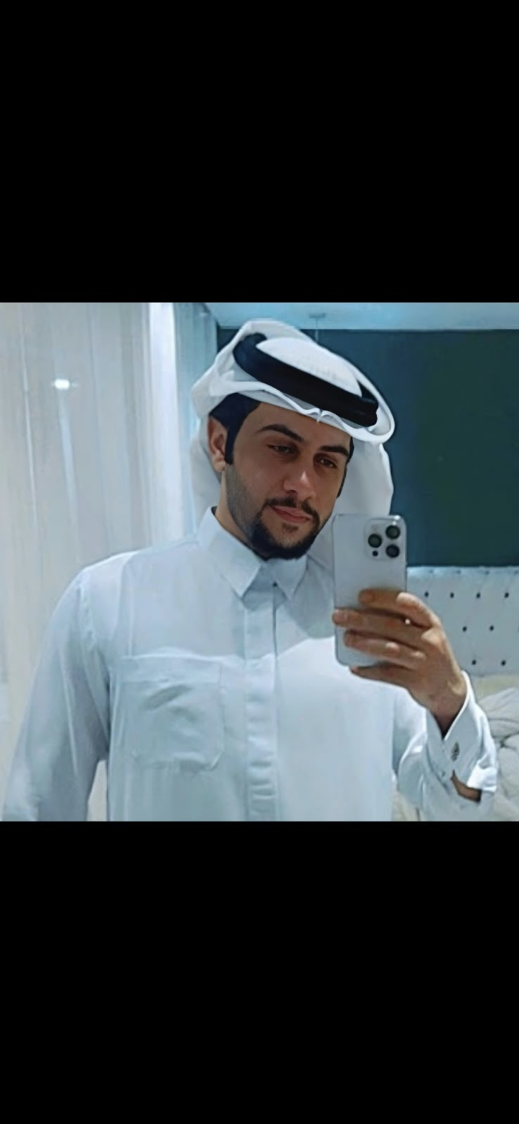Maher in traditional clothing taking a mirror photo
